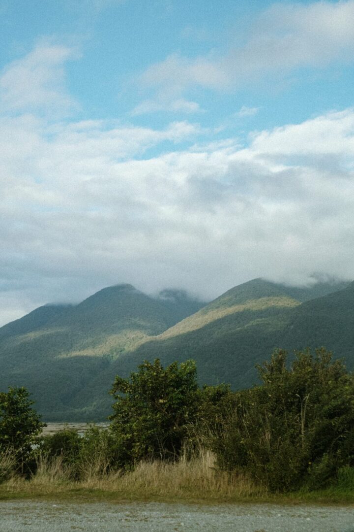 山に雲から溢れた日光が当たっている景色