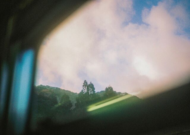 窓の外の夕暮れ。西日本は日が長い。雲の流れと電車の進みが合わさって、自分が今、確実な速度で移動していることを感じる。山を構成する木は音が聞こえそうなほど葉をゆらせているが、ディーゼル列車のモーター音と線路の繋ぎ目を車輪が踏む音がただひたすら車内に響いている。ゴー、カタンコトン。西陽を追いかけるように日本海に沿って移動した。#film #windowview #trainviews #snap #sunset